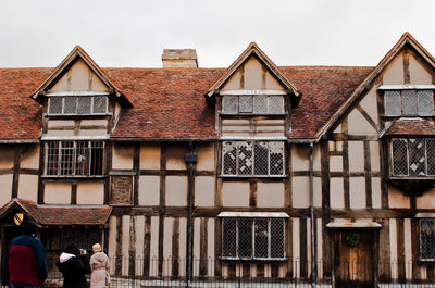 People outside house against sky