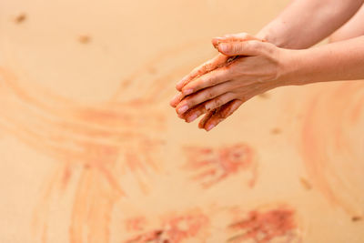 Cropped hands over sand at beach