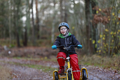 Boy cycling through forest