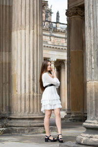Full length of woman standing against building in city