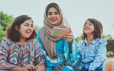 Mother with cheerful daughters enjoying at park