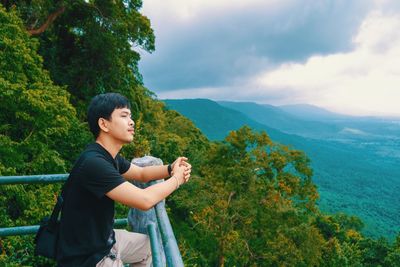 Side view of young man looking at mountain