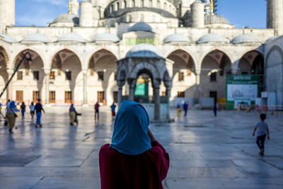 Rear view of woman against historic building