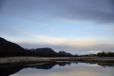 Scenic view of lake by mountain against sky