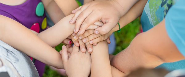 Midsection of kids stacking hands