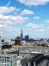 Buildings in city against cloudy sky