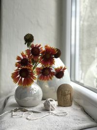 Close-up of flower vase on table against wall