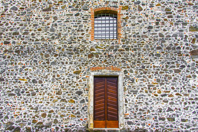 Wooden door with window of the parish church of san pietro a mare in lugo, vicenza, italy