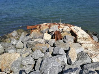 Rocks on sea shore against sky
