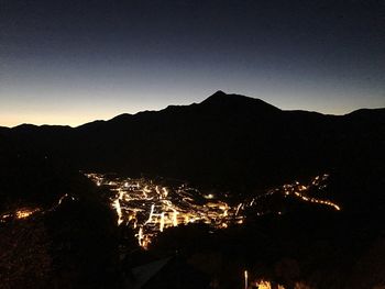 Illuminated cityscape against sky at night