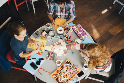 High angle view of multi-ethnic engineers working at table in creative office