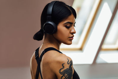 Young woman wearing headphones at gym