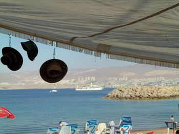 Clothes hanging by sea against sky