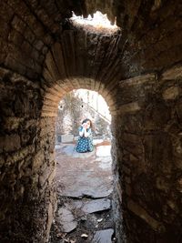 Portrait of girl seen through arch