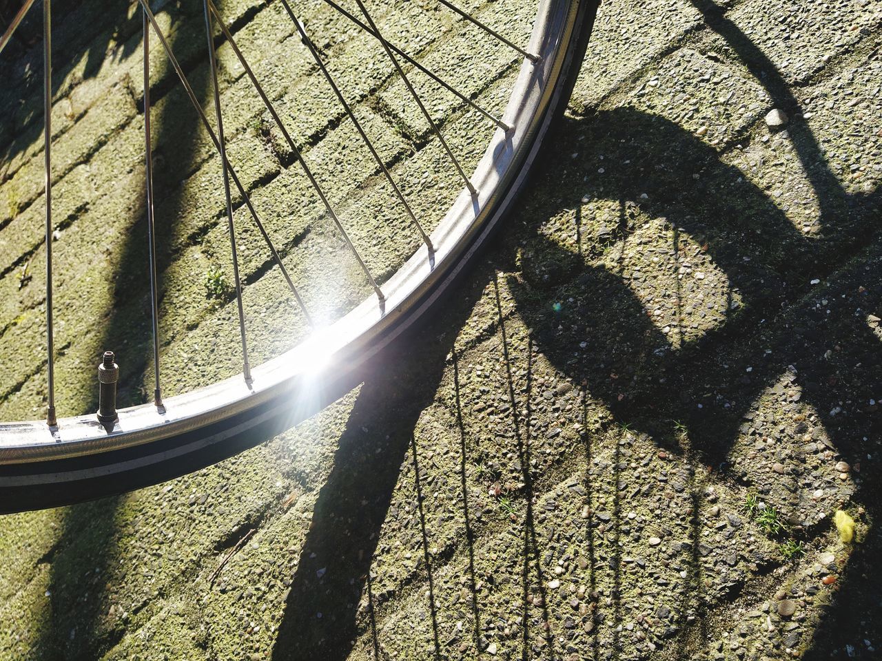 HIGH ANGLE VIEW OF SHADOW ON BICYCLE