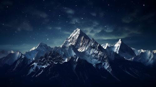 Scenic view of snowcapped mountains against sky at night