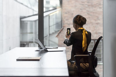 Businesswoman in office taking selfie