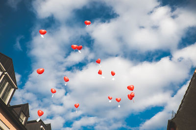 Low angle view of balloons flying against sky