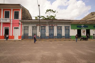 People walking on street against buildings in city