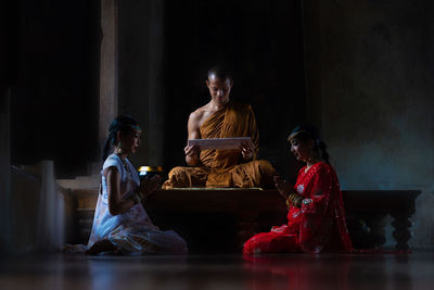 Monk with women praying in temple