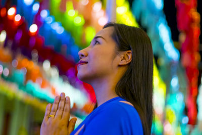 Portrait of young woman looking at multi colored light painting