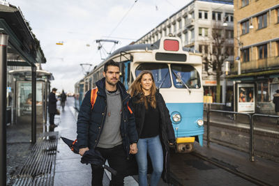 Full length portrait of young man on road in city