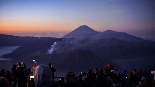 People at bromo-tengger-semeru national park against sky during sunset