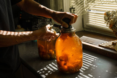 Midsection of person preparing food in glass on table