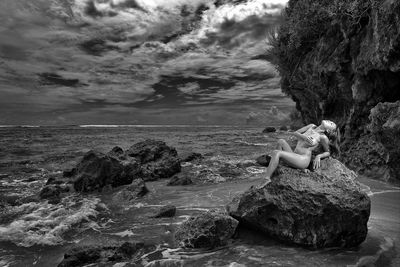 Scenic view of rocks on beach against sky