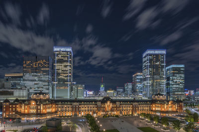 Illuminated buildings in city against sky at night