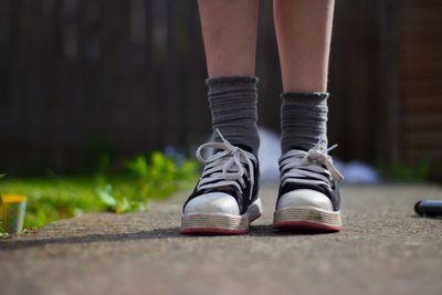 Low section of woman standing on footpath