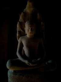 Buddha statue against black background