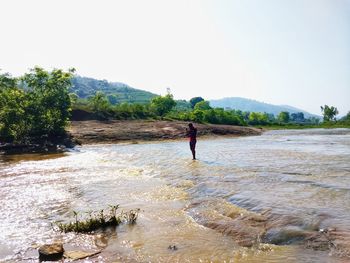 Man standing on shore against sky