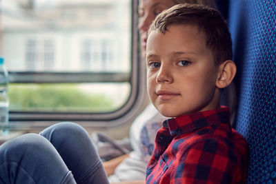 Portrait of boy looking through window