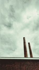 Low angle view of modern building against cloudy sky
