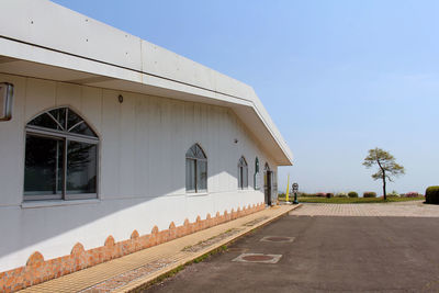 Road by building against clear sky