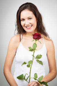 Portrait of smiling young woman against white background