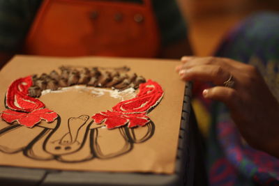 Cropped hands of woman making craft on table