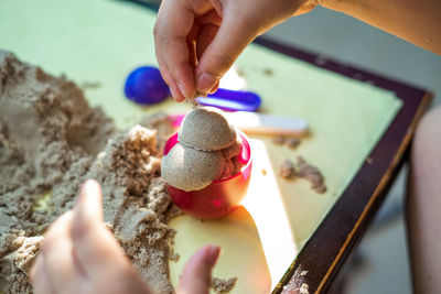 Close-up of child playing with toy and sand