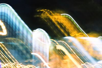 Blurred motion of illuminated ferris wheel in city at night