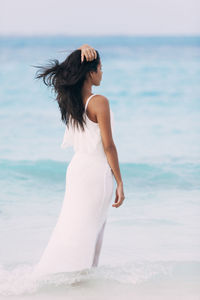 Rear view of woman with umbrella on beach