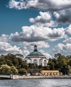 Lake by temple against sky