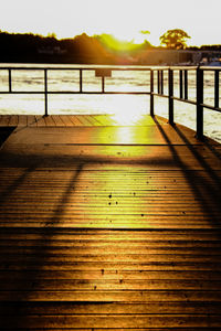 Wooden pier on lake against sky during sunset