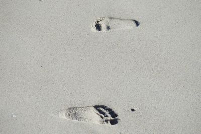 High angle view of footprints on sand at beach