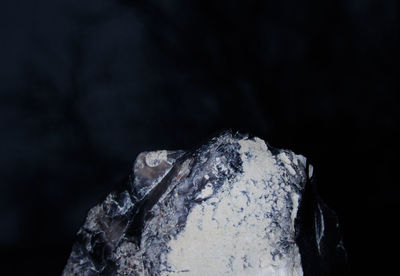 Close-up of ice on rock against black background