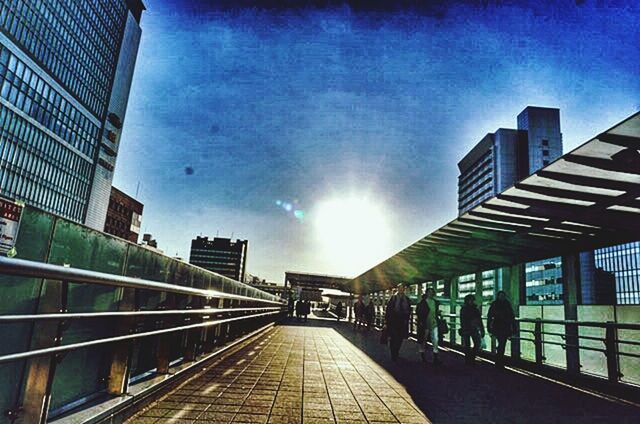 architecture, built structure, the way forward, building exterior, diminishing perspective, sky, vanishing point, city, sunlight, railing, building, sunbeam, transportation, sun, incidental people, cloud - sky, empty, lens flare, day, blue