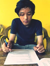 Close-up of young man sitting on table