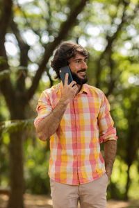 Young man at park on a beautiful sunny day with mobile phone.  working  leisure. green and nature 