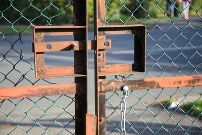 Close-up of padlock on chainlink fence