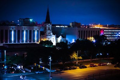 Illuminated buildings against sky at night